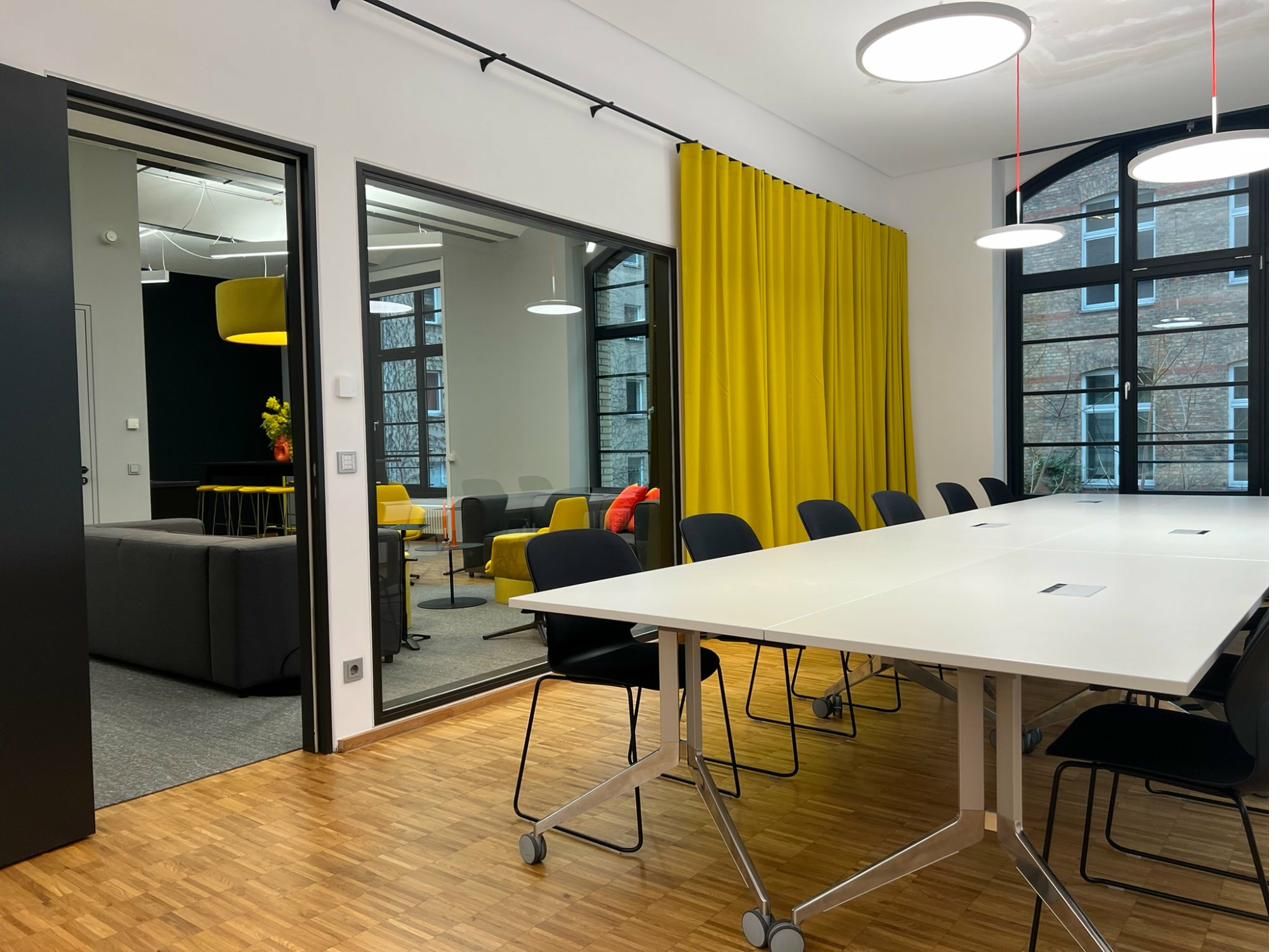 Meetingraum mit bodenlangen Vorhängen und warmem Licht