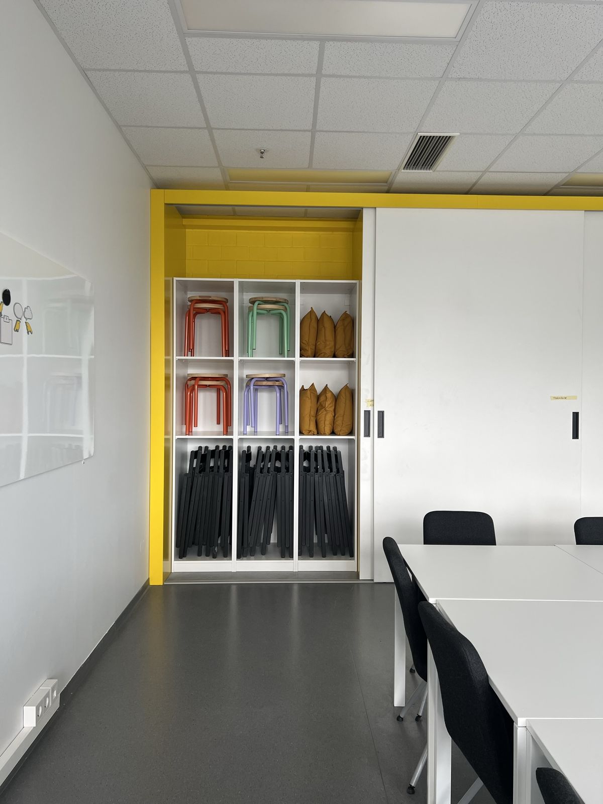 Schulungsraum-Detail mit Regal und Arbeitsmaterialien