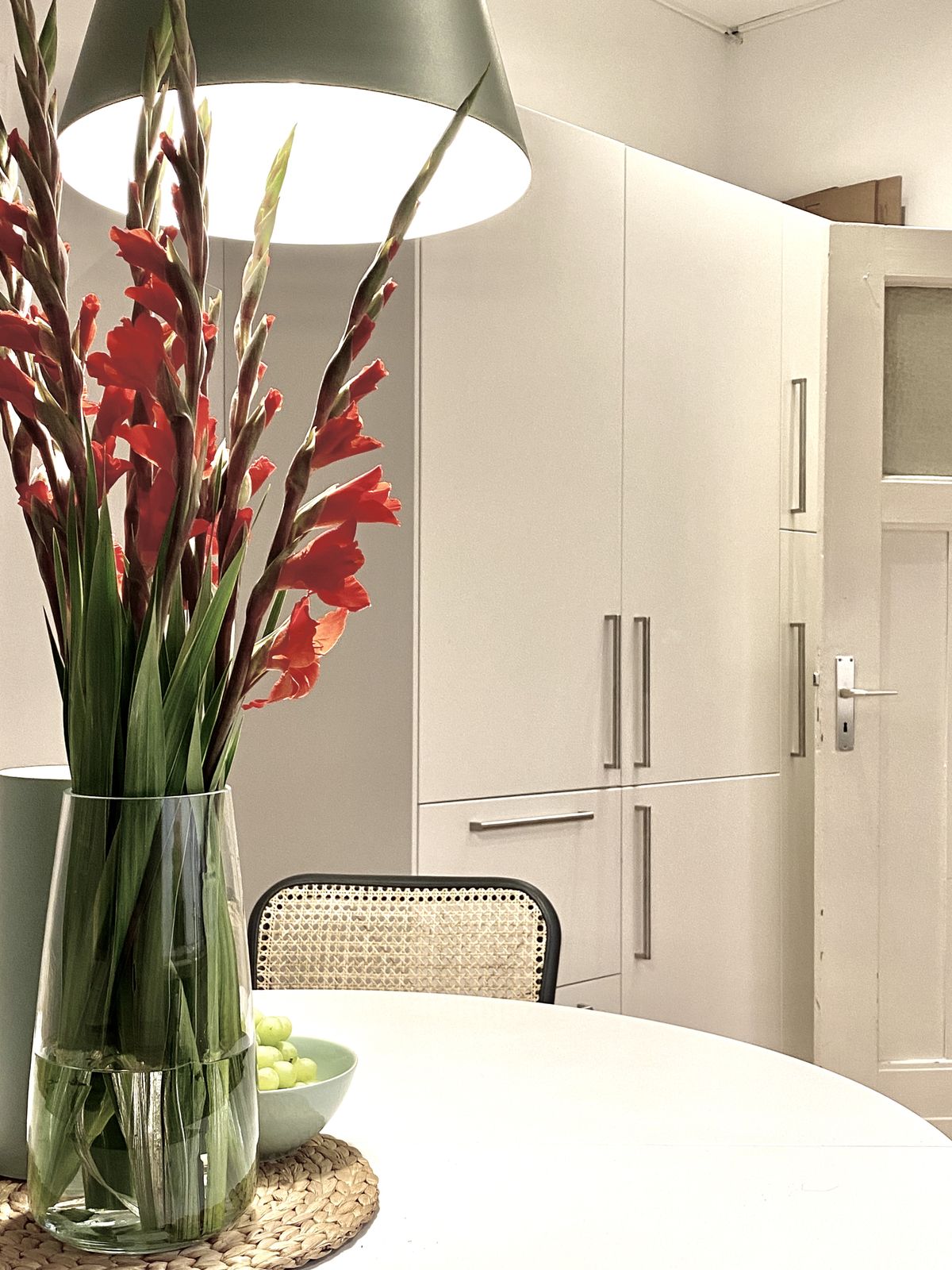 Detailansicht der Küchenzeile mit hellen Fronten, integrierten Geräten und natürlichen Materialien